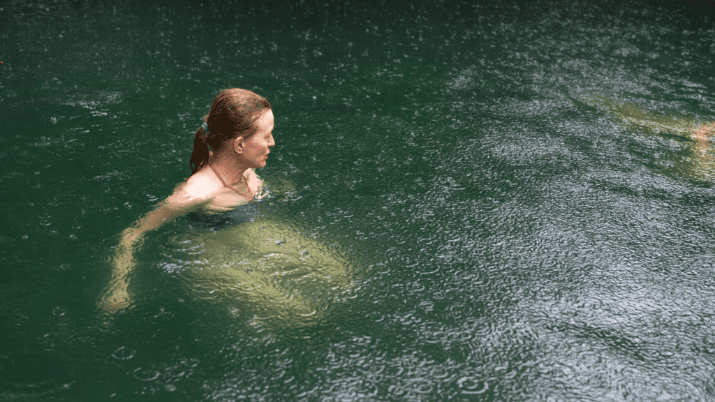 Portrait of senior woman relaxing on rain in outdoor Hot Springs at foot of Volcano Arenal, Costa Rica.