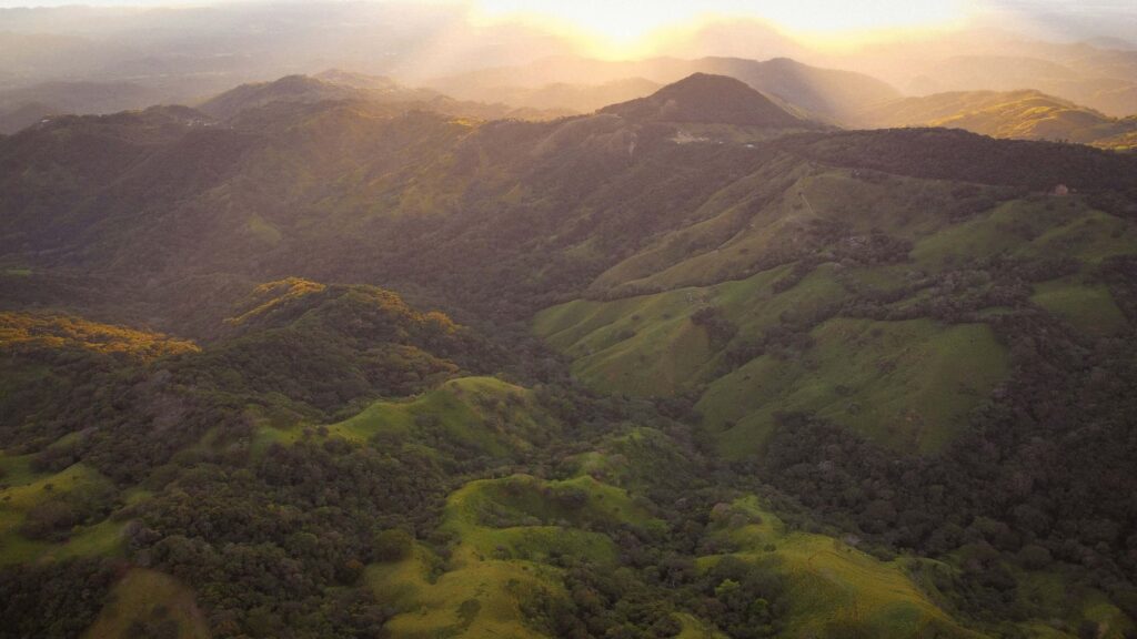 Aerial view of the green mountain range surrounding Monteverde and the Santa Elena Cloud Forest Reserve area at sunset, Costa Rica
